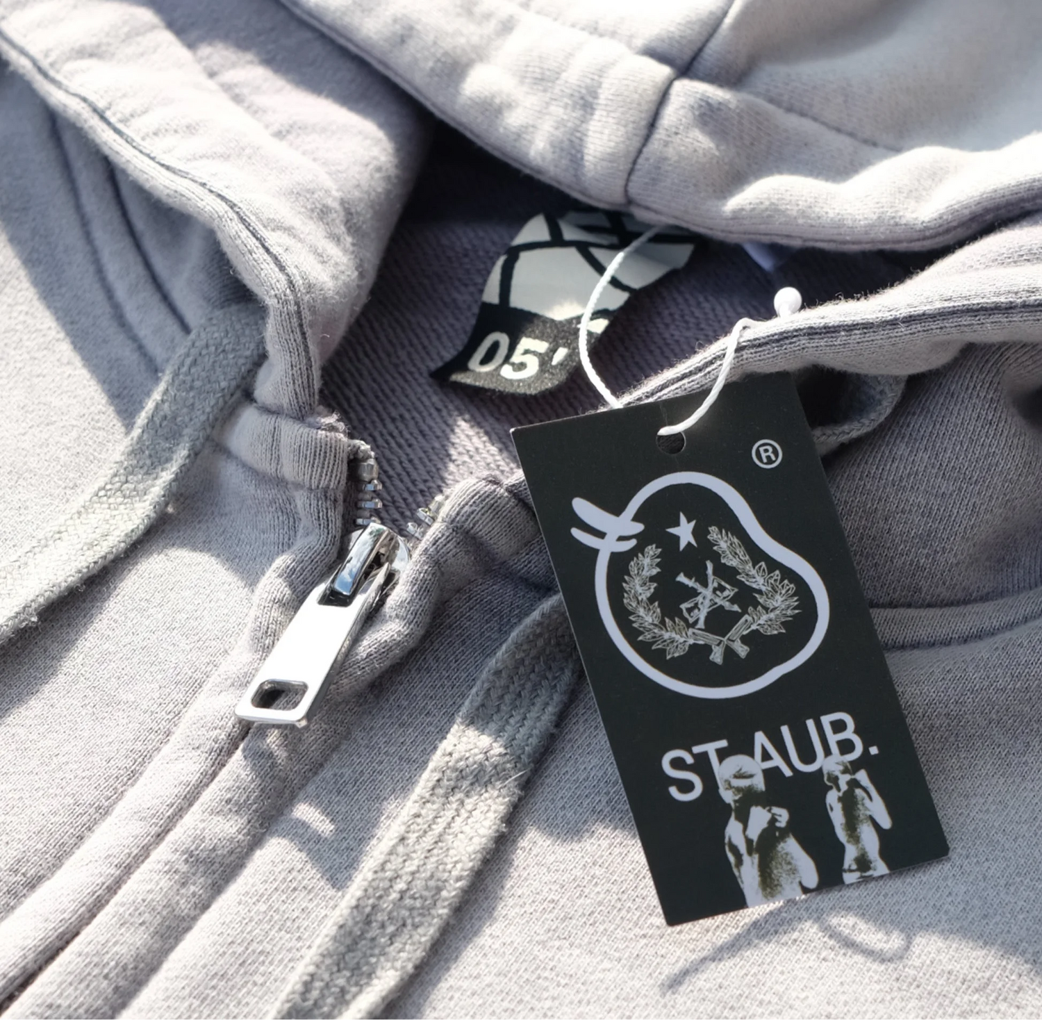 Saint Aub Zip Hoodie détail — Fermeture éclair cordons blancs tag noir héritage
